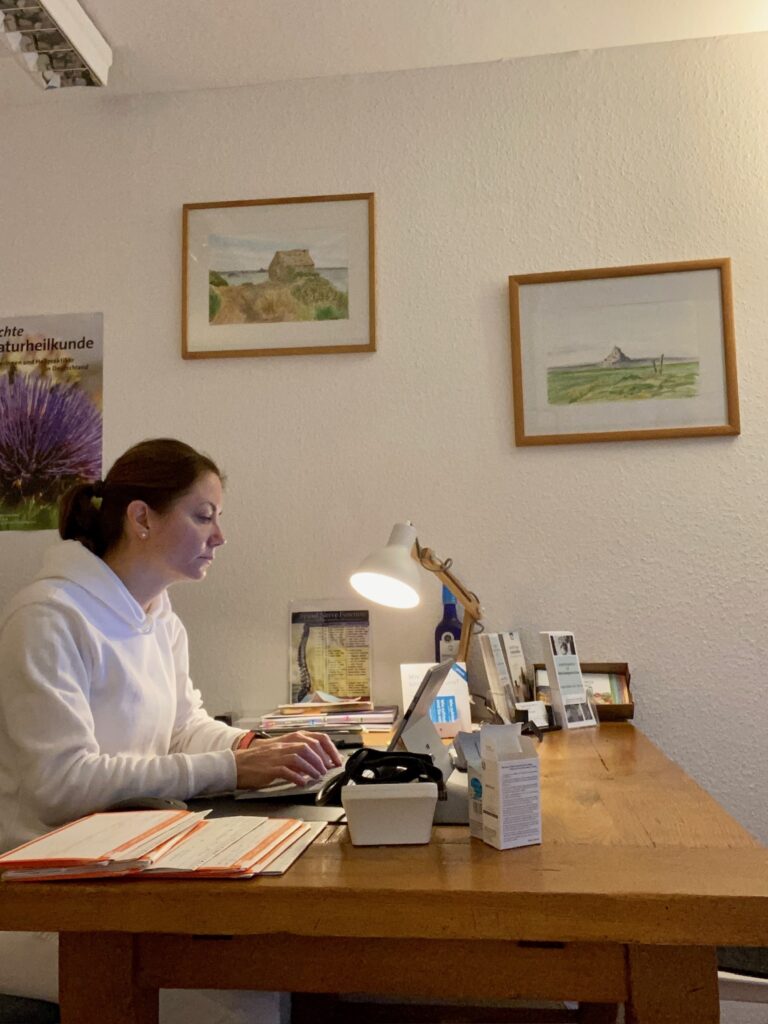 Amélie Haas im Vorgespräch an ihrem Schreibtisch in der Kölner Praxis